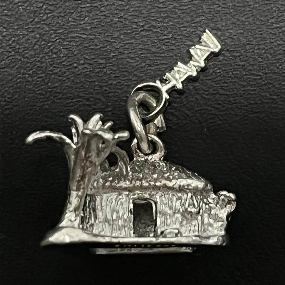 Hawaii Charm or Pendant Sterling Silver.

Palm Tree, Grass Hut and Hawaii tag.